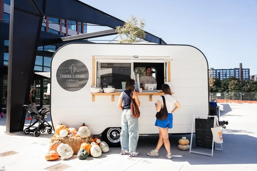 Customers ordering from the open window of a Prickly Pear Coffee Co. trailer